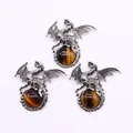 Detailed view of silver Viking dragon pendants clutching spherical tiger eye stones - Tiger's Eye