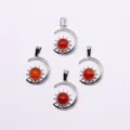 Detail of silver sun and moon pendants with round red gemstones on white background - Red Agate