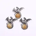 Macro detail of antique silver dragon pendants holding yellow tiger eye stones - Coral Jade