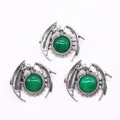 Macro shot of three vintage silver dragon charms with emerald green stone accents - Malay Jade