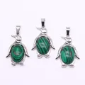Detailopname van drie pinguïnhangers met groene stenen voor DIY-sieradenaccessoires. - Malachiet