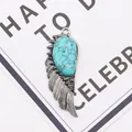 Macro detail of angel wing pendant with turquoise stone inlay and engraved feathers - 21x58mm / Blue Turquoise