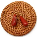 Close-up of polished teardrop red jasper stones with natural textures on a woven base - Red Jasper
