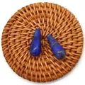 Pair of teardrop-shaped lapis lazuli beads with natural gold flecks on a woven mat - Lapis Lazuli