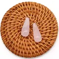Macro view of teardrop rose quartz stones with natural texture on a woven tray - Rose Quartz