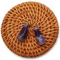 Macro view of two polished teardrop-shaped purple amethyst beads on a woven mat - Purple Crystal