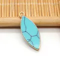 Detalle macro del colgante turquesa marquesa con borde chapado en oro y aro de metal - Turquesa Azul Claro