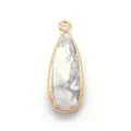 Macro view of teardrop white turquoise pendant with textured gold plated metal edges - Howlite