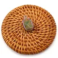 Detail shot of faceted natural Unakite stone pendant with silver-plated edge on rattan mat - Unakite