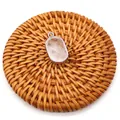 Detailed top view of natural oval crystal pendant with silver plated edge on woven mat - White Crystal