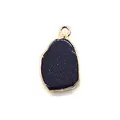 Close-up of blue goldstone pendant with gold plated edge and irregular shape - Blue Sandstone