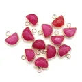 Dettaglio macro di pendenti a semicerchio in pietra naturale con bordi placcati oro - Giada rosa rosso