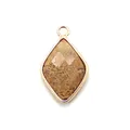 Macro detail of diamond-shaped natural stone pendant with gold plated metal edges - Jasper