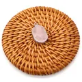 Faceted rose quartz oval pendant with silver plated edges on a rustic straw mat - Rose Quartz