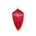 Macro view of shield-shaped red agate stone pendant with fine gold electroplated edge - Rose Red Chalcedony