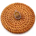 Tiger eye stone oval pendant with silver plated edge on a woven background - Tiger's Eye