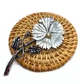 Macro shot of natural shell flower brooch with pearl center on a woven rattan mat - Pointed Petal Vintage Floral Style (No.5)