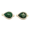 Macro shot of two teardrop malachite charms with zircon accents and gold plating - No.3 (Green Malachite Texture)