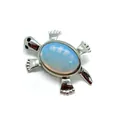 Schildkröten-Brosche aus Silber mit ovalem milchig-blauem Edelstein auf weißem Grund - Opal