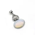 Macro shot of silver hollow gourd pendant with translucent gemstone and zircon inlay - 2.8cmx4.7cm / Opal
