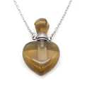 Macro detail of a heart-shaped natural stone perfume bottle pendant with silver chain - Smoky Quartz