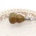 Primo piano del ciondolo a forma di zucca in pietra unakite con catena argento - Unakite