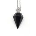 Macro shot of a black obsidian hexagonal perfume bottle pendant with silver metal cap - Black Agate