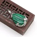 Dettaglio macro del ciondolo in malachite a goccia con intagli floreali in argento - Malachite