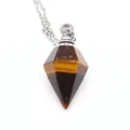 Macro view of a hexagonal tiger eye stone essential oil bottle pendant on silver chain - Tiger's Eye