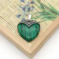 Macro-opname van malachiet hartvormige hanger met vintage zilveren golfpatroon gravure - Malachiet
