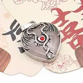 Detailed close-up of a heart-shaped gemstone pendant with silver dragon wrap and red zircon - Rose Quartz / 32x41mm