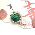 Detail view of retro dragon claw pendant holding a striped green turquoise bead - Malachite