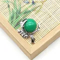 Macro shot of green gemstone ball held by silver dragon claw setting on bamboo mat - Green Agate (No.4)