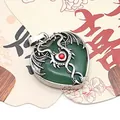 Detailed view of a silver dragon wrapped around a heart-shaped green stone pendant - Green Aventurine / 32x41mm