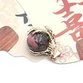 Pink gemstone ball pendant featuring a golden dragon claw clasp design for jewelry DIY - Rhodonite with Black Lines