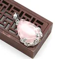 Ciondolo in quarzo rosa a goccia con montatura floreale argentata su portagioie in legno - Quarzo rosa