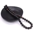 Perle in pietra naturale grigio scuro con macchie rosse su espositore nero - No. 23