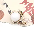 Golden dragon claw pendant holding a white round pearl with a frosted metal finish - White Jade