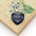 Blauwe goudsteen hartvormige hanger met zilveren kap op bamboe achtergrond - Blauwe zandsteen