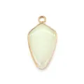 Detailed view of shield-shaped green gemstone pendant with gold-plated metal edging - Xinschan Jade