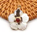 Vue macro d'un pendentif fleur avec pétales en nacre blanche et pierre centrale rouge - Agate rouge