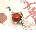 Deep red stone pendant with a gold dragon claw design and textured scale finish - Red Jasper
