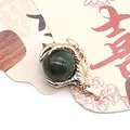 Golden dragon claw pendant featuring a polished dark green turquoise gemstone bead - India Agate