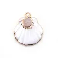 Close-up of shell-shaped jewelry pendant with white inlay and pink stone set in gold frame - Rose Quartz