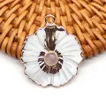 Détail macro d'un pendentif fleur en or avec pétales en nacre blanche et pierre rose - Quartz rose