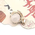 Golden dragon claw pendant featuring a round white translucent natural stone bead - White Crystal