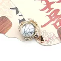 Golden dragon claw pendant holding a white natural stone bead with grey marble texture - White Howlite Bracelet