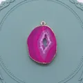 Vue détaillée du pendentif géode d'agate rose rouge avec bords dorés sur plateau bleu - Rose (No.6)