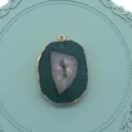 Vue détaillée du pendentif en agate verte avec bord doré sur un plateau décoratif - Vert (No.5)