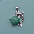 Detailed view of a silver dolphin pendant hugging a round green natural stone bead - Green Aventurine